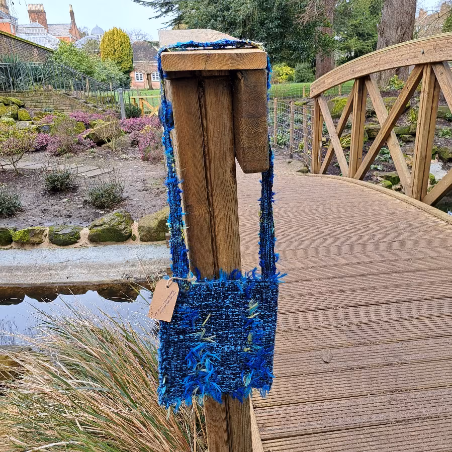 Square Novelty Bag hanging from bridge