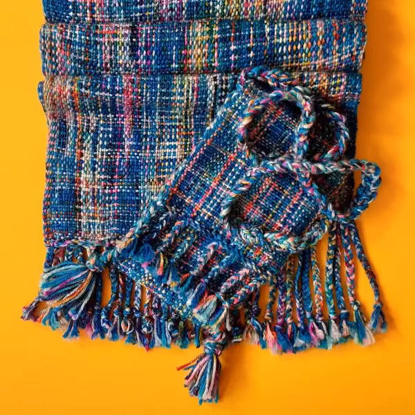 Deep blue scarf flecked with pink and turquoise, with a matching small purse and tasselled fringe