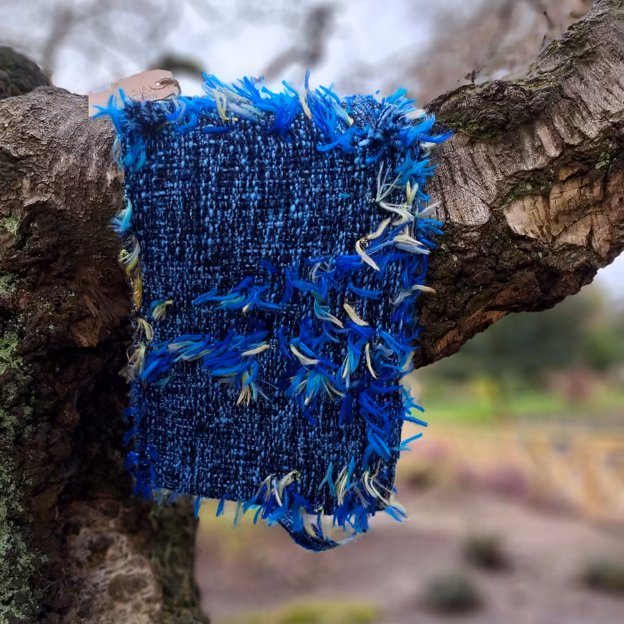 The back of the blue shaggy bag, resting against tree bark